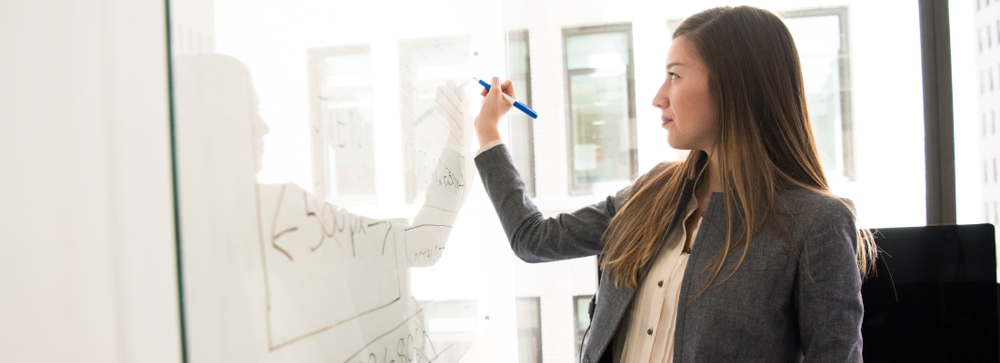 Woman writing on whiteboard